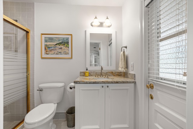 bathroom with tile patterned flooring, vanity, toilet, and walk in shower