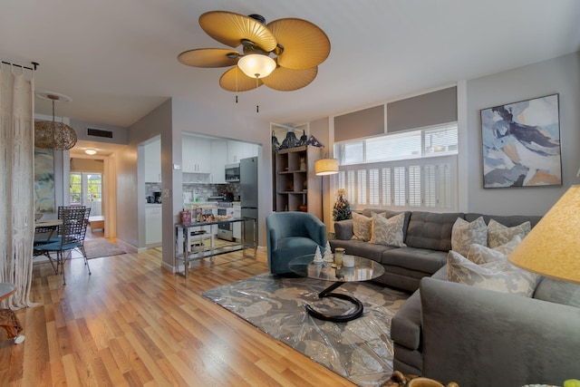 living room with ceiling fan and light hardwood / wood-style flooring