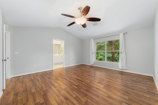 empty room with dark hardwood / wood-style floors, ceiling fan, and vaulted ceiling