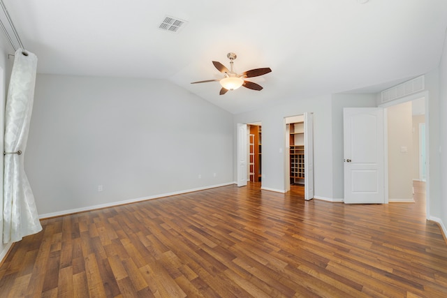 unfurnished bedroom with ceiling fan, dark hardwood / wood-style flooring, lofted ceiling, a walk in closet, and a closet