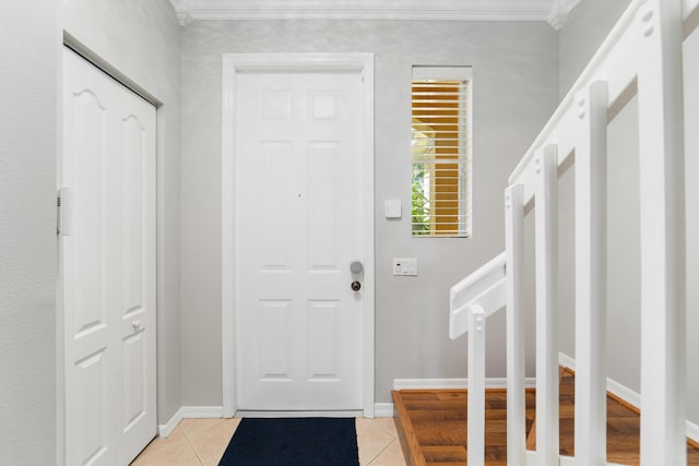 tiled entrance foyer featuring crown molding