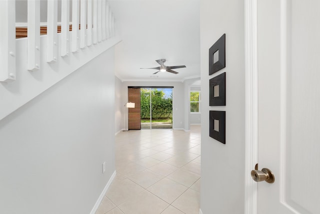 corridor featuring ornamental molding and light tile patterned floors