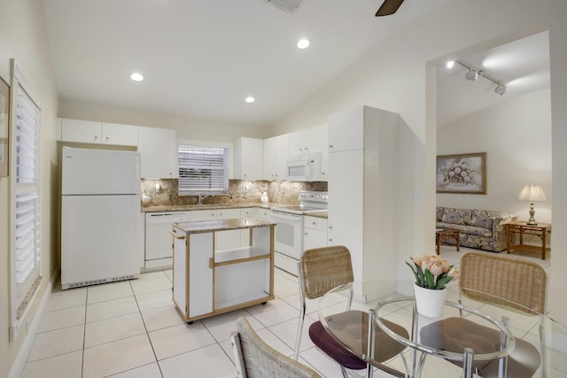 kitchen featuring a center island, white appliances, light tile patterned flooring, and vaulted ceiling