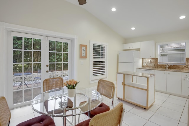 dining space with recessed lighting, vaulted ceiling, french doors, and light tile patterned flooring