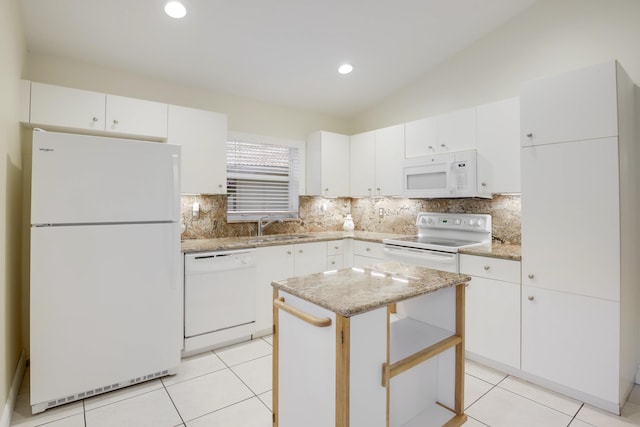 kitchen featuring white appliances, vaulted ceiling, a sink, and light tile patterned flooring