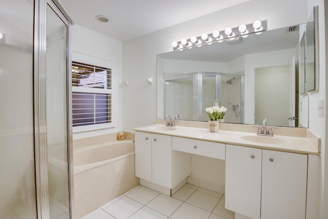 bathroom with a stall shower, tile patterned flooring, a sink, and a bath