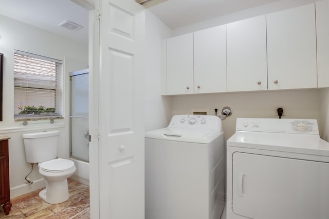 washroom featuring cabinets and washer and clothes dryer