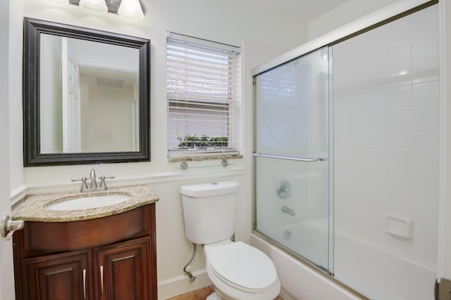 full bathroom featuring toilet, shower / bath combination with glass door, and vanity