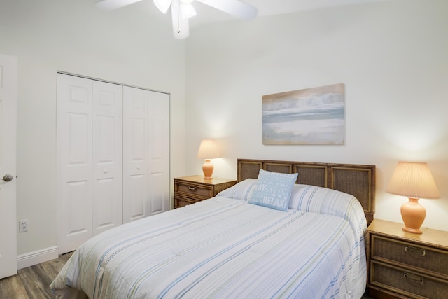 bedroom with a closet, wood finished floors, a ceiling fan, and baseboards