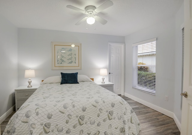 bedroom featuring dark wood-style floors, baseboards, and a ceiling fan