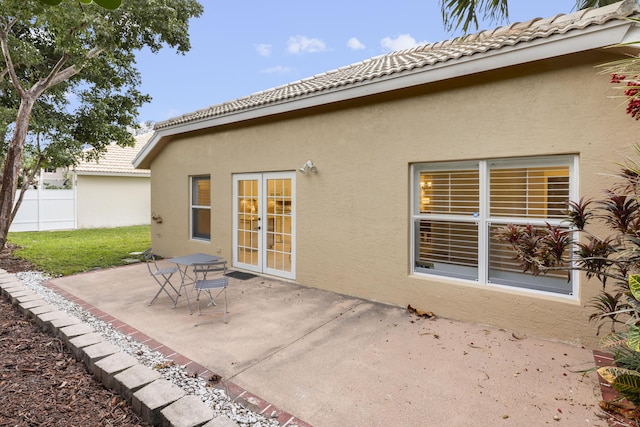 back of property with a patio area, a tiled roof, fence, and stucco siding