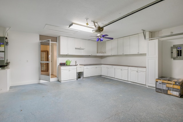 garage featuring electric panel, a garage door opener, and ceiling fan