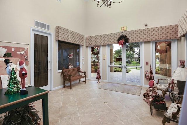 tiled foyer with a towering ceiling and an inviting chandelier