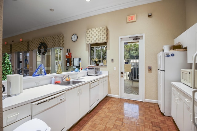 kitchen with white appliances, light parquet floors, crown molding, sink, and white cabinets