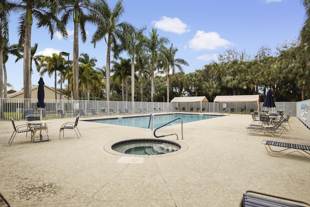 view of swimming pool featuring a patio and a hot tub