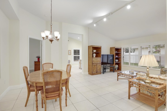 dining room with track lighting, vaulted ceiling, baseboards, and light tile patterned floors