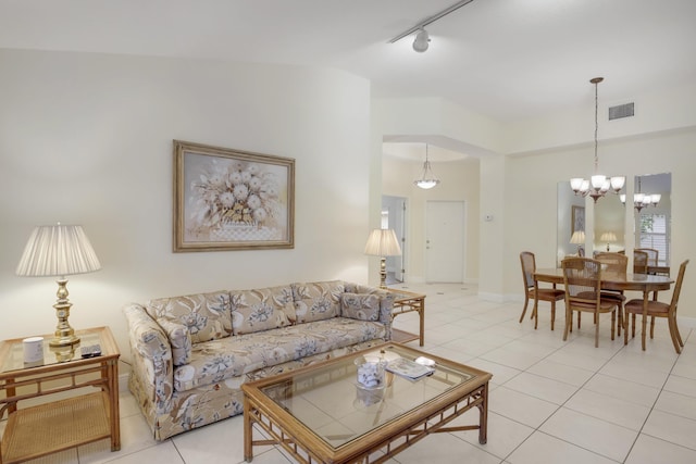 tiled living room with a notable chandelier and track lighting