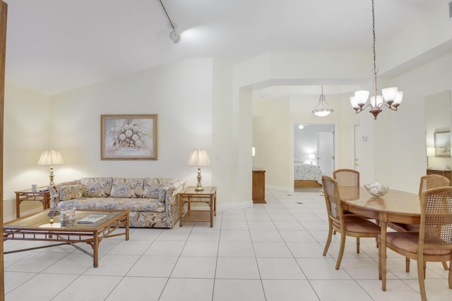 tiled living room with track lighting, lofted ceiling, and a chandelier