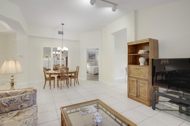 living area with light tile patterned floors, visible vents, baseboards, an inviting chandelier, and track lighting