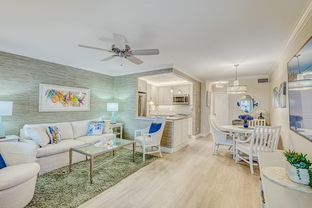 living room with ceiling fan, light hardwood / wood-style floors, and ornamental molding