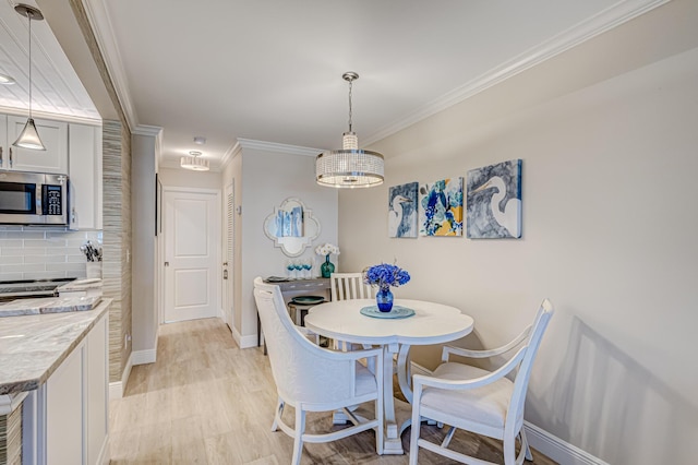 dining room featuring light hardwood / wood-style flooring and crown molding