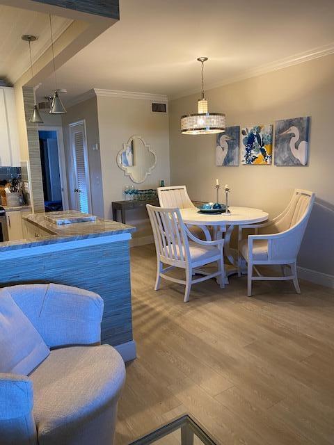 dining room featuring hardwood / wood-style floors, breakfast area, and ornamental molding