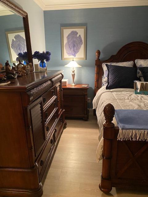 bedroom featuring light hardwood / wood-style flooring and ornamental molding