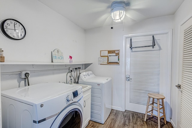 laundry room featuring cabinets, washer and clothes dryer, and wood-type flooring