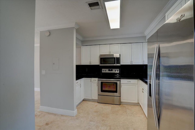 kitchen featuring white cabinets, crown molding, appliances with stainless steel finishes, and tasteful backsplash