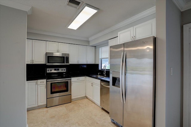 kitchen with crown molding, white cabinetry, sink, and appliances with stainless steel finishes