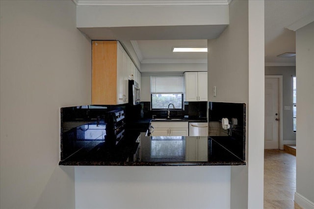 kitchen with backsplash, white cabinets, sink, crown molding, and stainless steel appliances