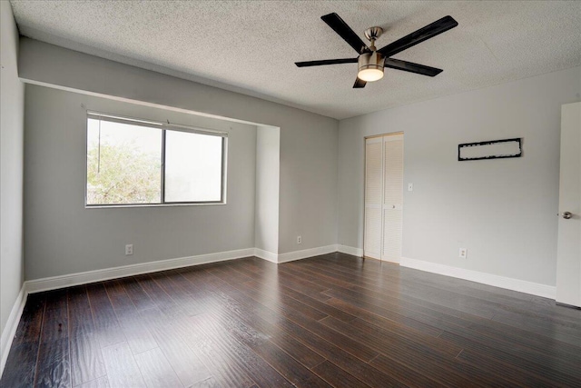 spare room with dark hardwood / wood-style floors, ceiling fan, and a textured ceiling