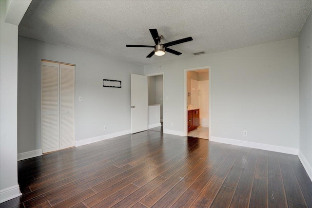 spare room with ceiling fan, dark wood-type flooring, and a textured ceiling