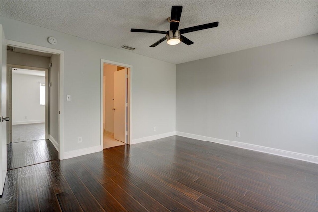 unfurnished room featuring ceiling fan, dark wood-type flooring, and a textured ceiling