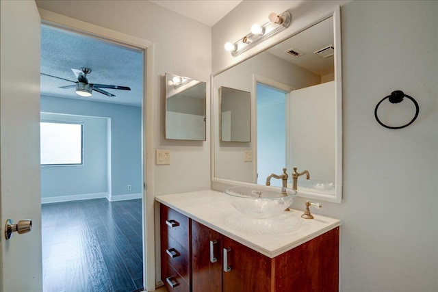 bathroom with hardwood / wood-style flooring, ceiling fan, and vanity