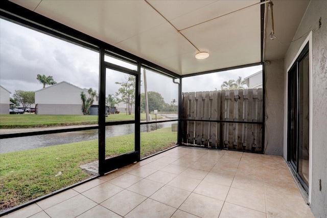 unfurnished sunroom featuring a water view