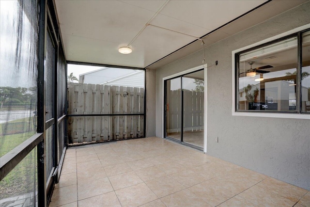 unfurnished sunroom with ceiling fan