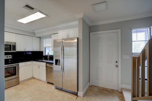 kitchen with white cabinetry, sink, backsplash, appliances with stainless steel finishes, and ornamental molding