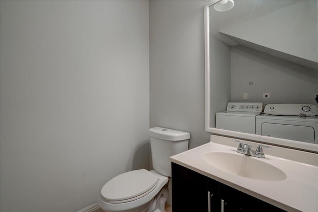 bathroom featuring vanity, toilet, and washer and clothes dryer