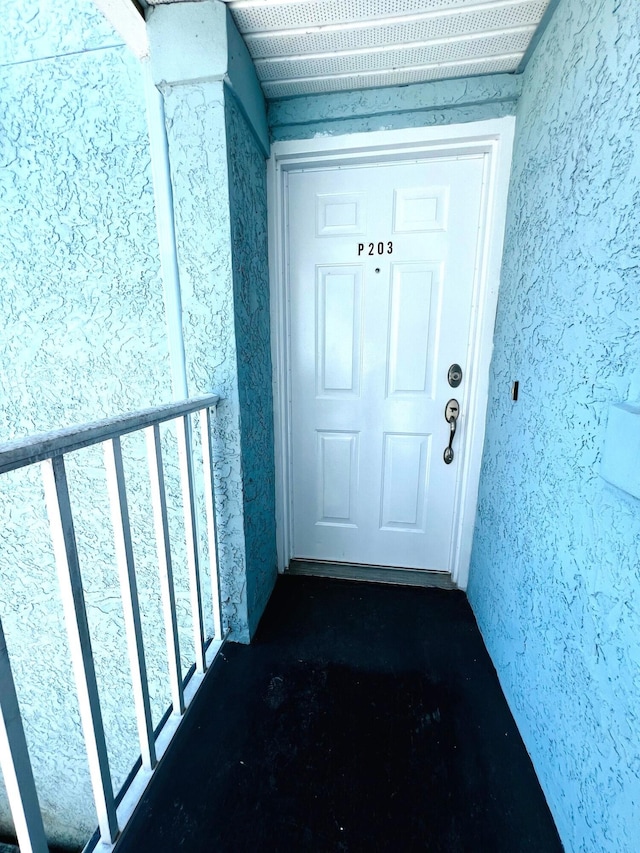 view of exterior entry with a balcony