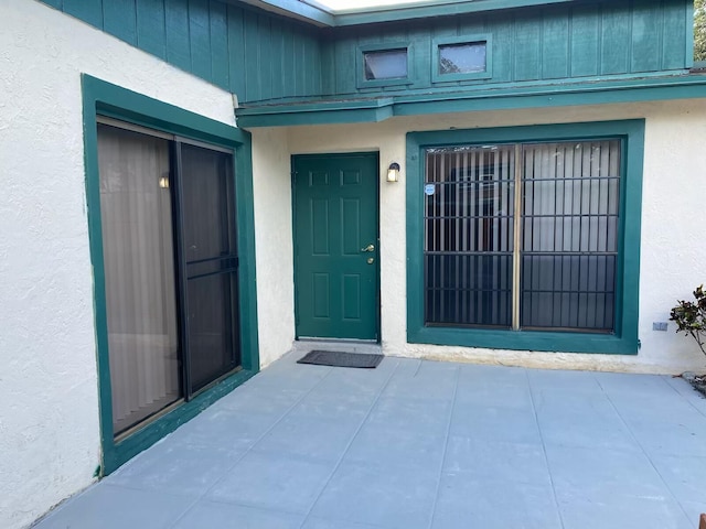 view of exterior entry with a patio area