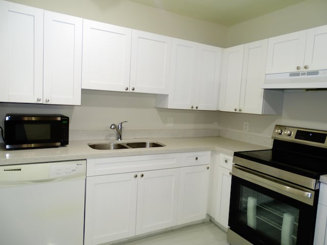 kitchen with stainless steel appliances, white cabinetry, and sink