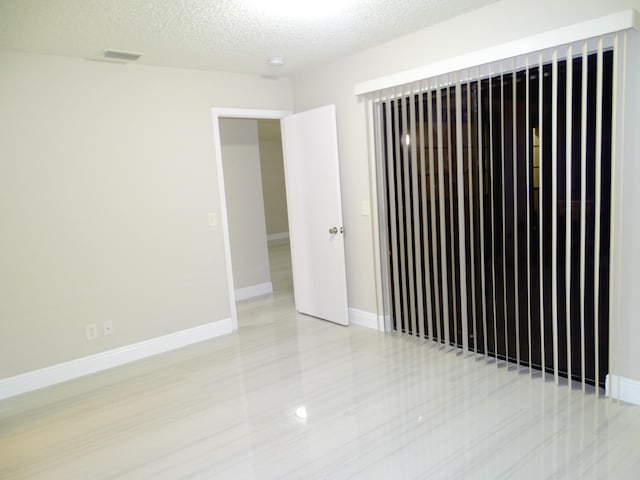 spare room with a textured ceiling