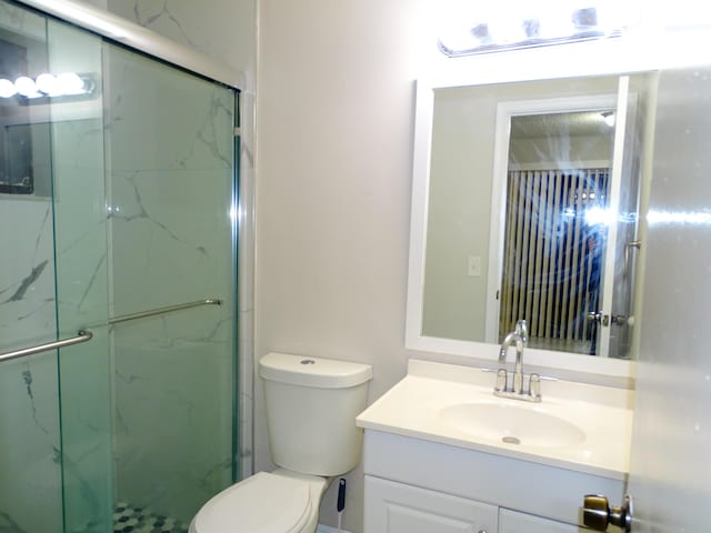 bathroom featuring vanity, toilet, and walk in shower