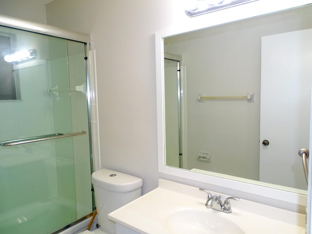 full bathroom with vanity, toilet, and bath / shower combo with glass door