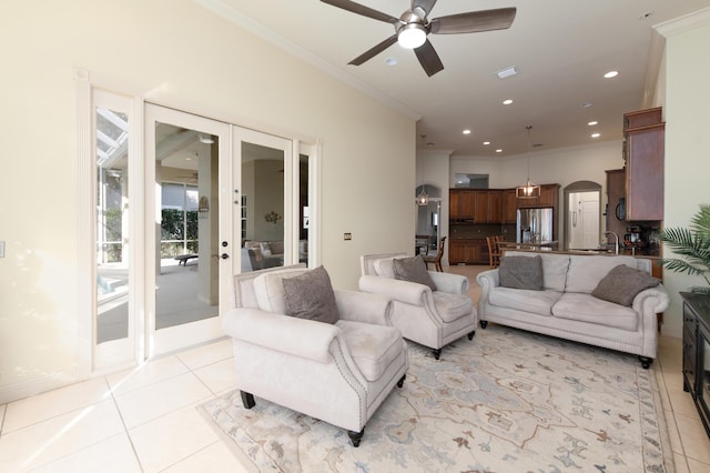 tiled living room featuring crown molding, sink, ceiling fan, and french doors