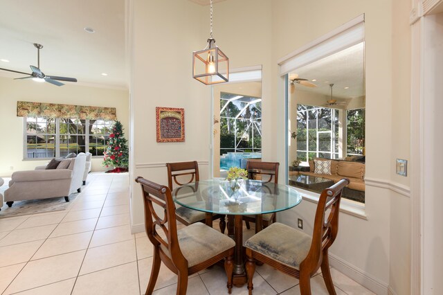 tiled living room with indoor wet bar, ceiling fan, and crown molding