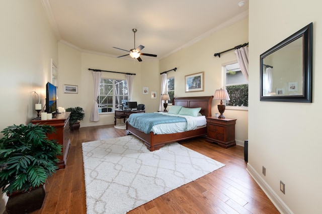 bedroom with crown molding, ceiling fan, dark hardwood / wood-style flooring, and multiple windows