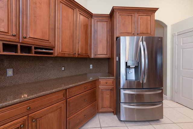 18640 SE River Ridge Rd, Jupiter, FL 33469 - kitchen featuring stainless steel refrigerator with ice dispenser, light tile patterned floors, and brown cabinetry