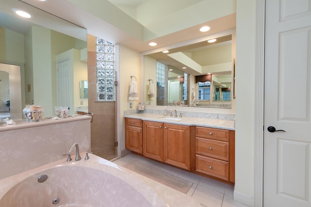 bathroom with tile patterned flooring, vanity, and a tub